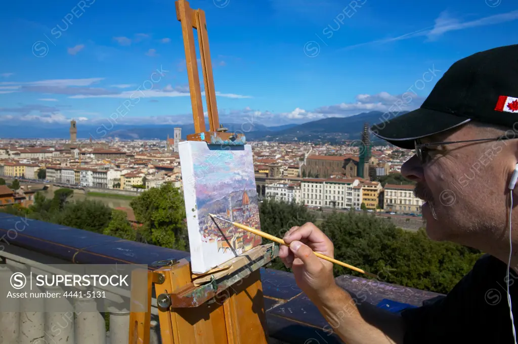 An artist painting the view of Florence and the Arno River from Piazzale Michelangiolo. Florence. Italy