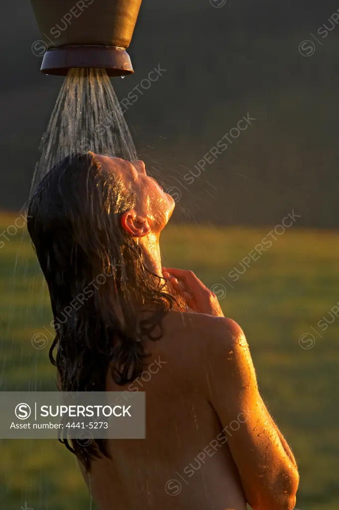 Woman in outdoor shower. Kamberg. KwaZulu Natal. South Africa