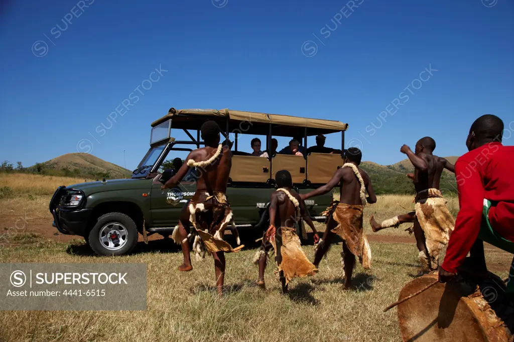 Local Zulu boys dancing for tourists in game drive vehicle just outside Hluhluwe Imfolozi Park. KwaZulu Natal. South Africa