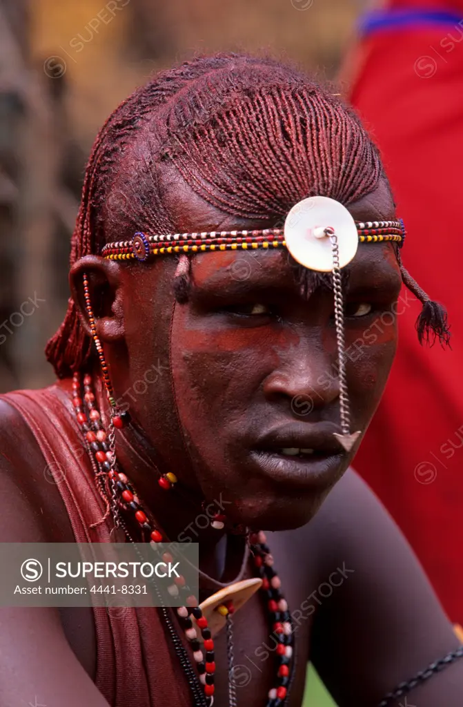 A Maasai warrior showing his coiffure of ochred braids. The moran spend many hours preening. Olonana village.
