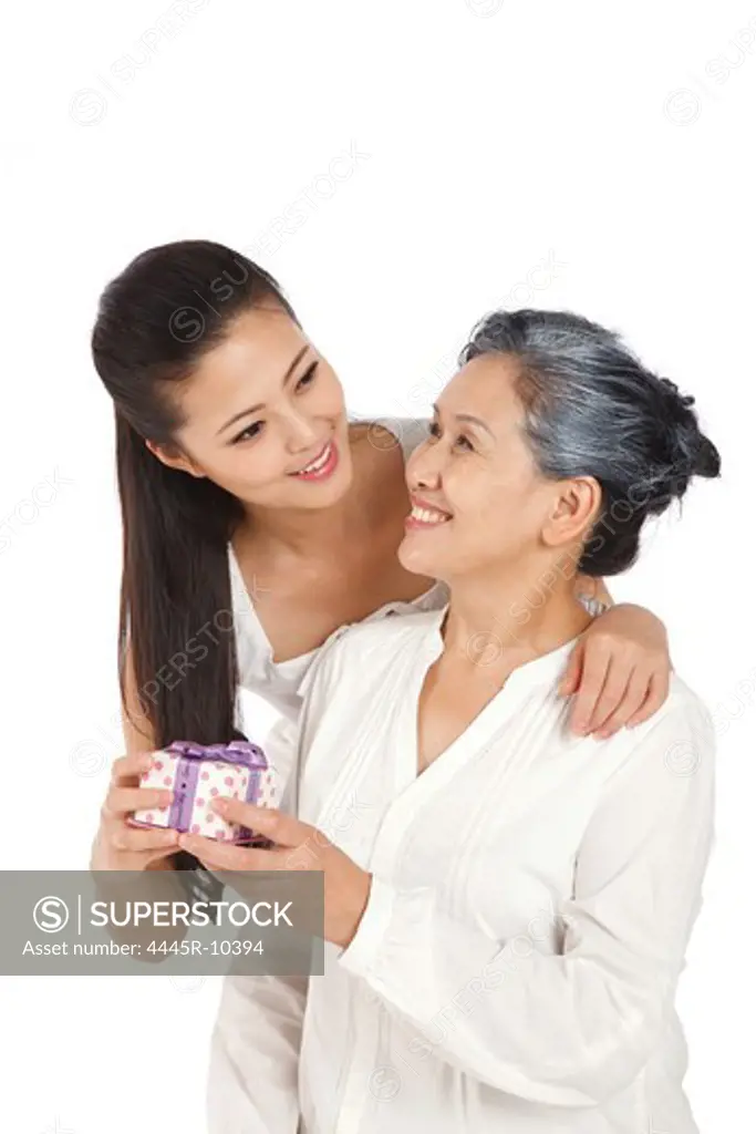 Young woman giving mother gift