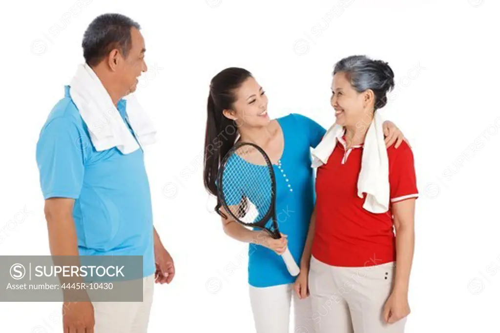 Young woman and parents playing tennis