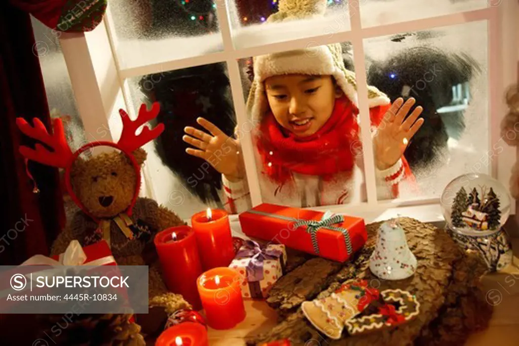 Boy looking at Christmas gift through window