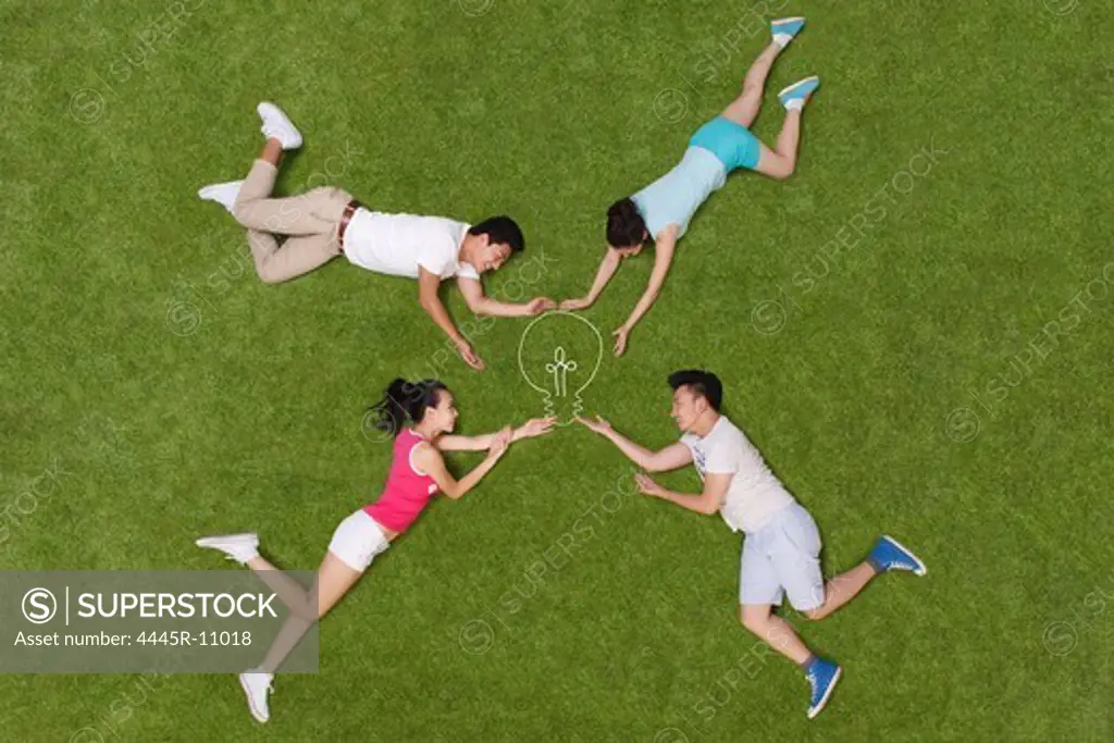 Young people lying on grass playing