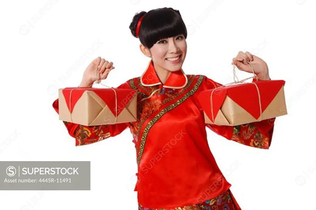 Young woman dressed in Chinese traditional clothes holding two wrapped boxes on Chinese New Year