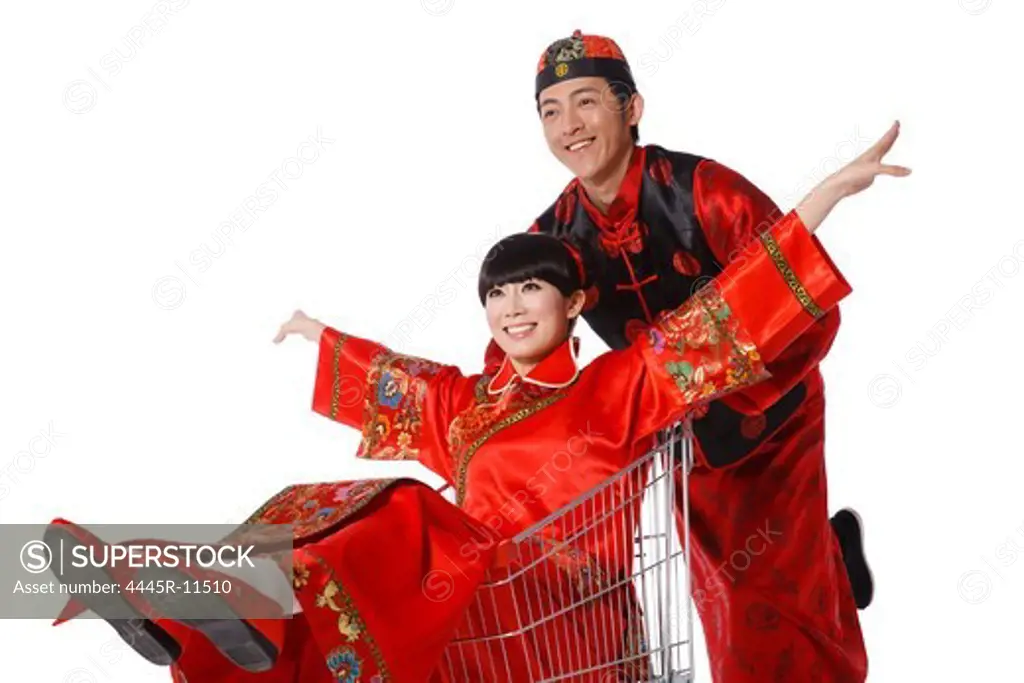 Young couple dressed in traditional clothes shopping with cart