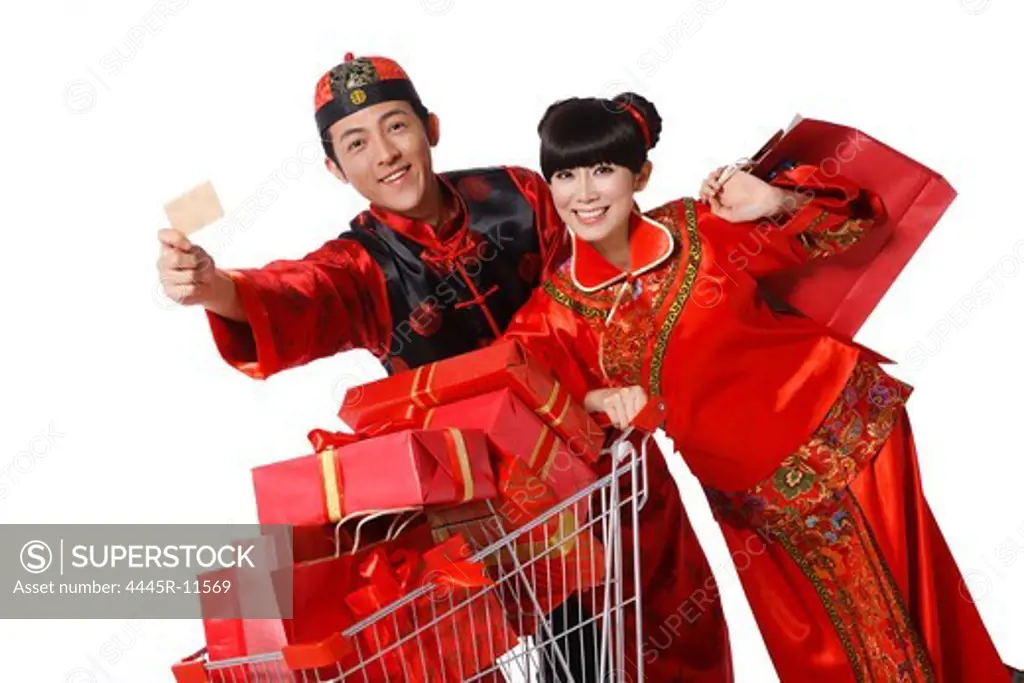 Young couple dressed in traditional clothes shopping with cart