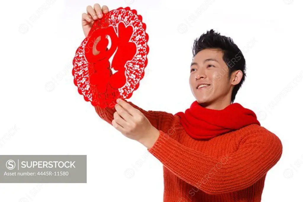 Young man holding red paper cut-out