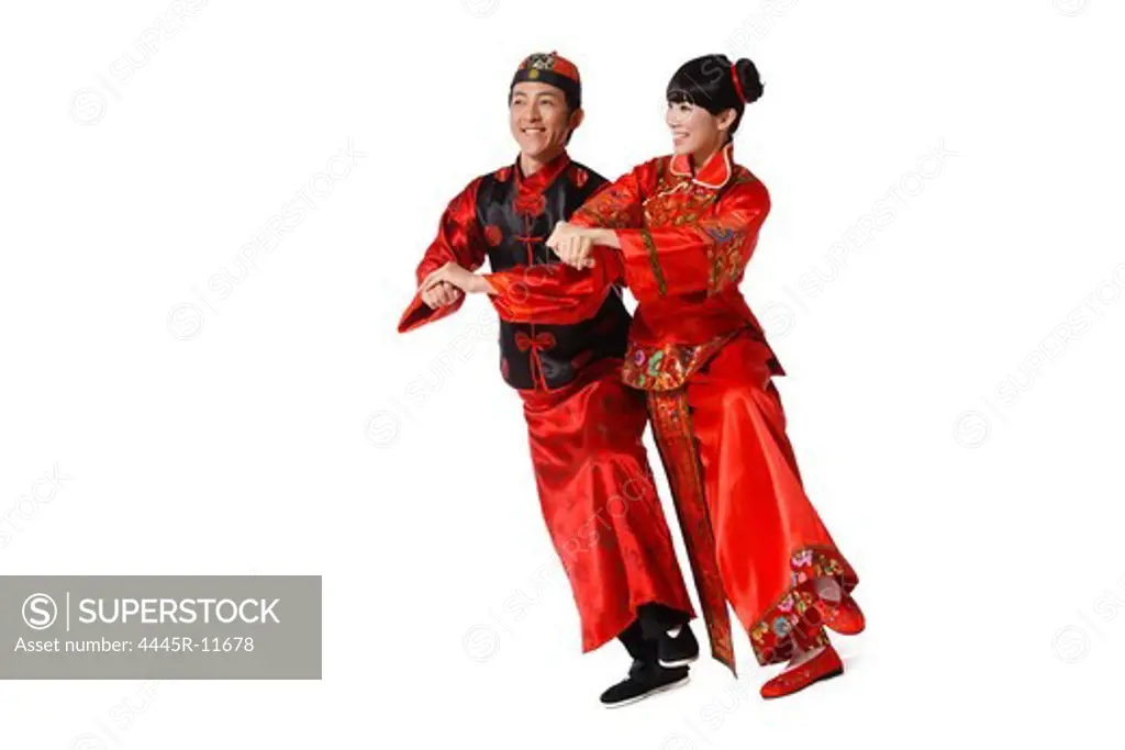 Young couple dressed in traditional clothes dancing celebrating Chinese New Year