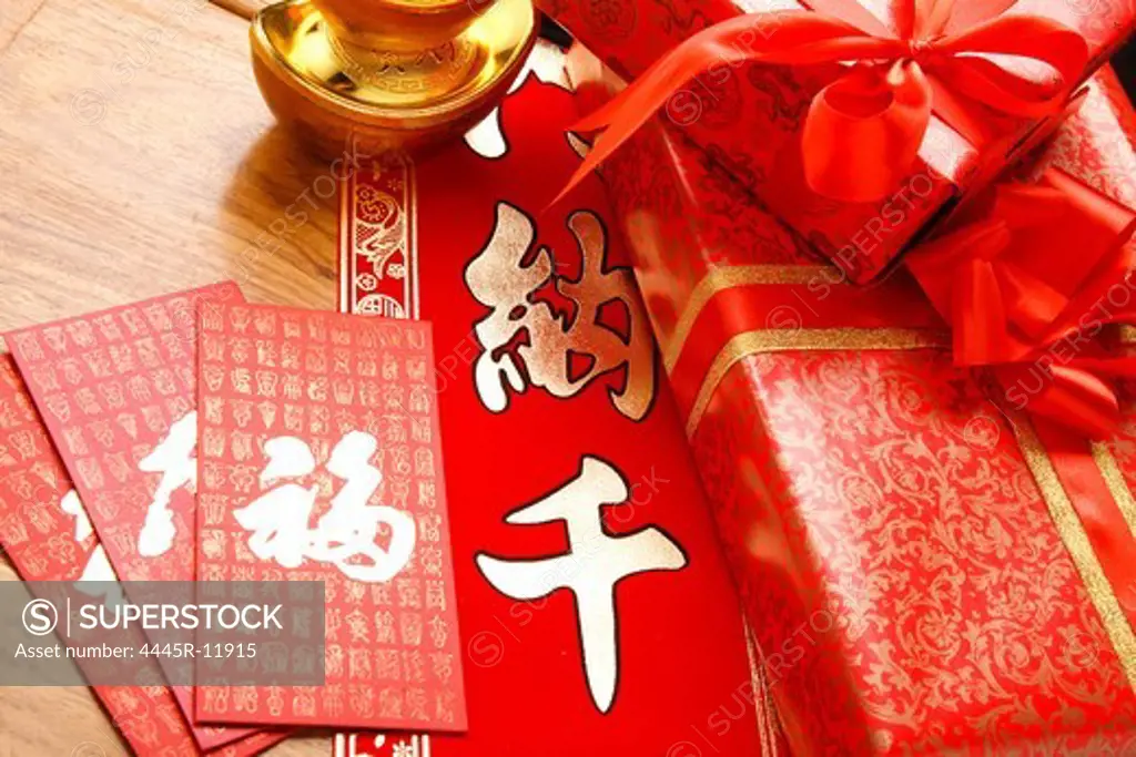 Close-up of gold ingots and red envelopes