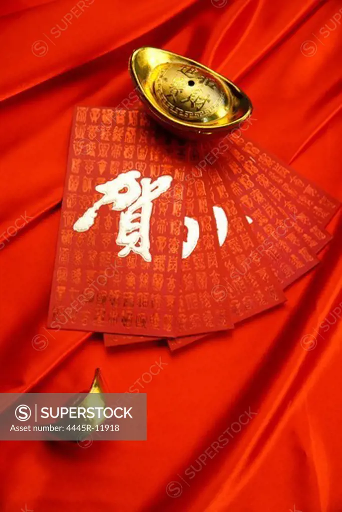 Close-up of gold ingots and red envelopes