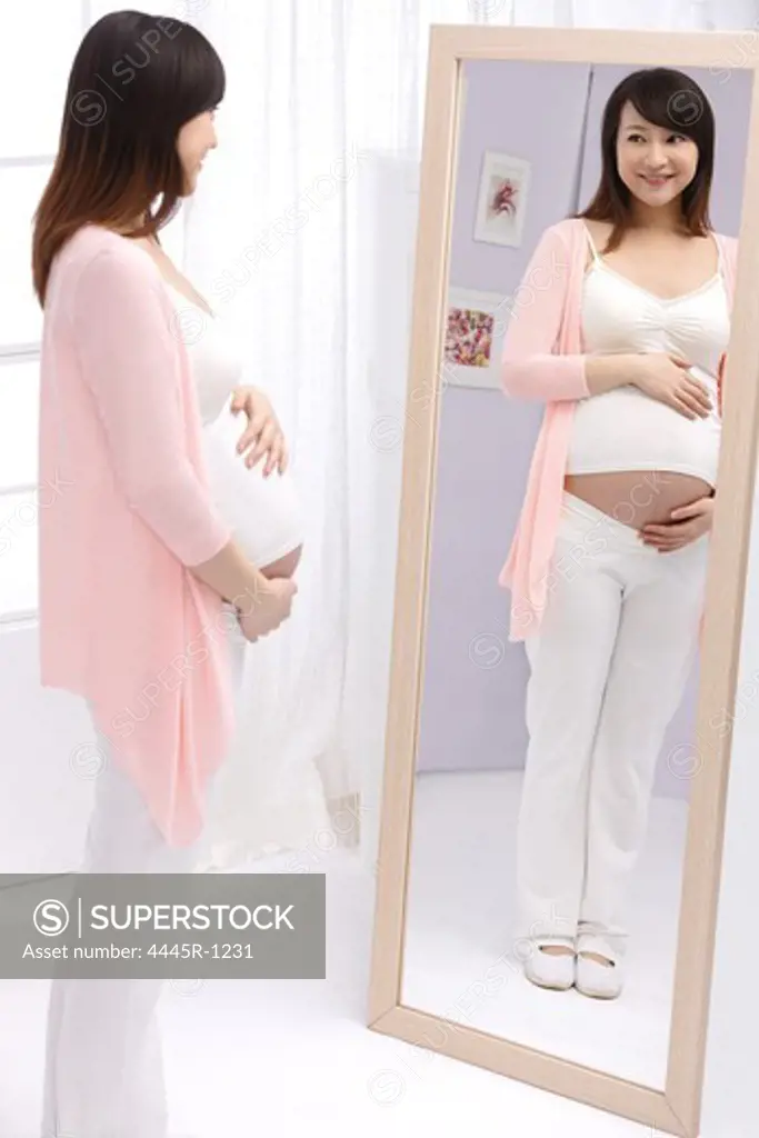 Pregnant woman looking in mirror