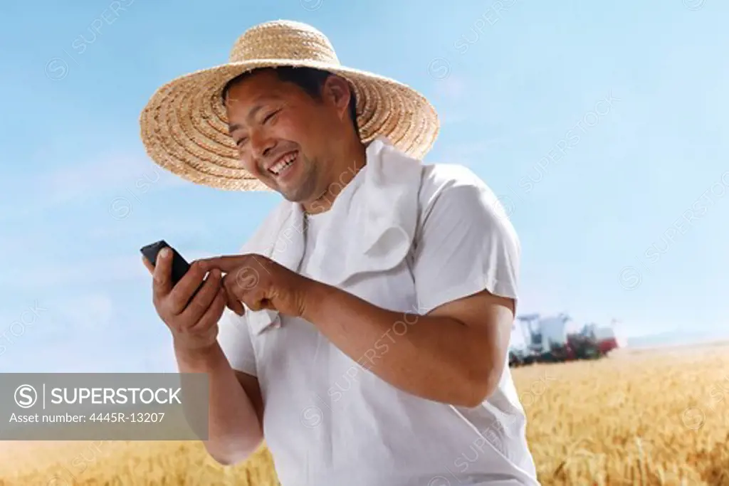 Farmer making phone call in wheat field