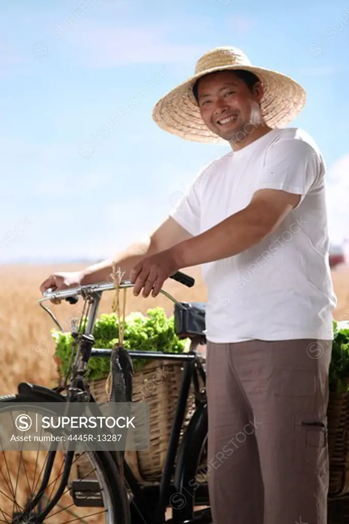 Farmer walking bike with vegetable