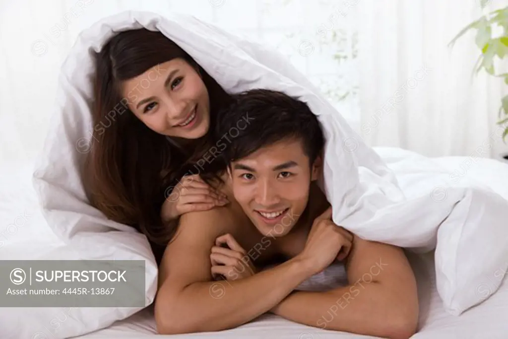 Young couple lying prone on bed