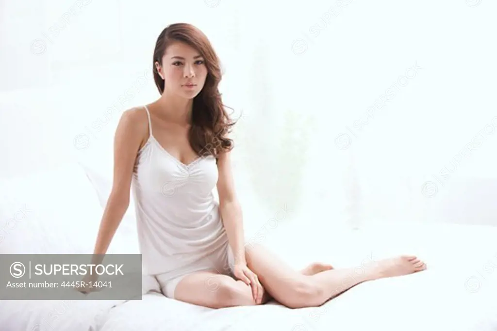 Young lady sitting on bed