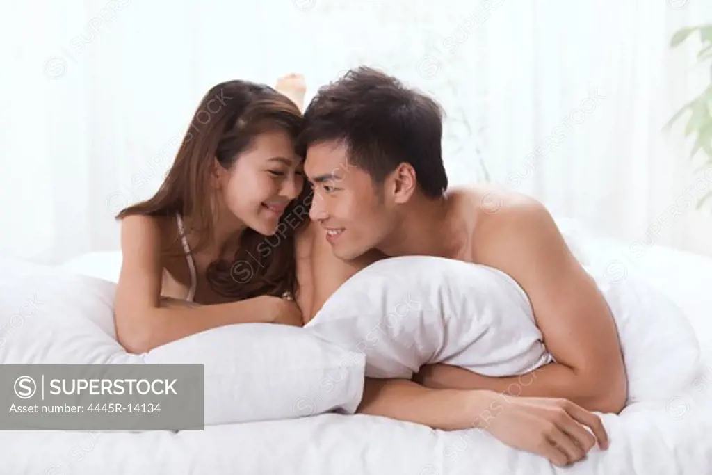 Young couple lying prone on bed