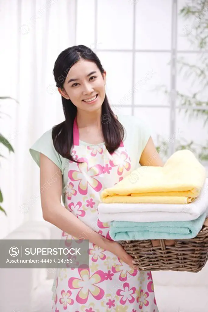 Young woman holding basket of towels