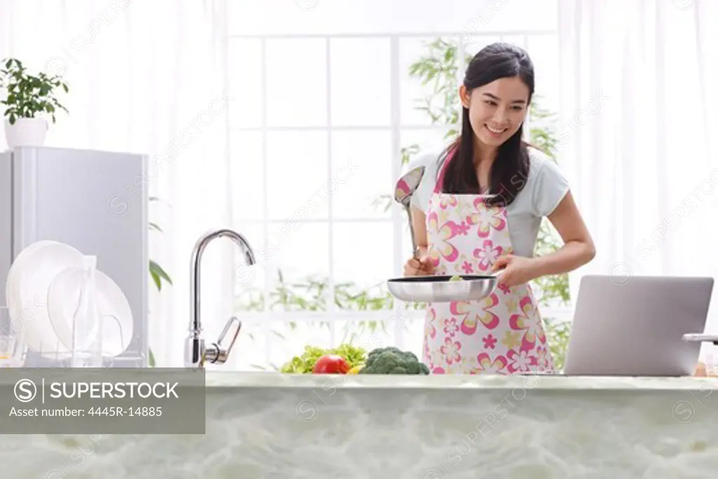 Young woman learning cooking in kitchen