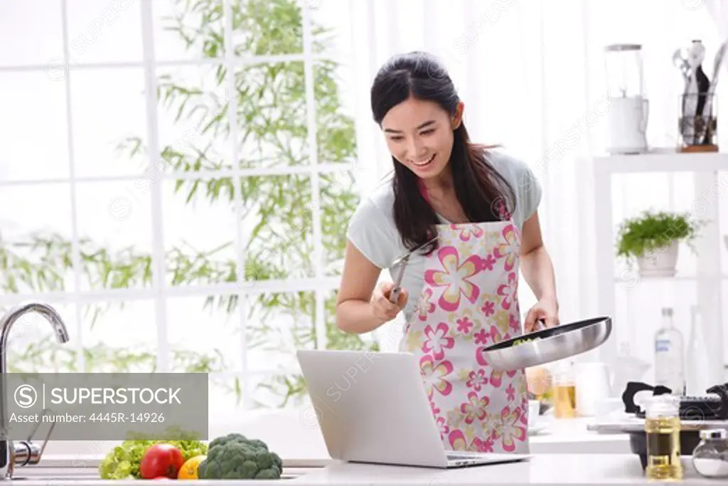 Young woman learning cooking in kitchen