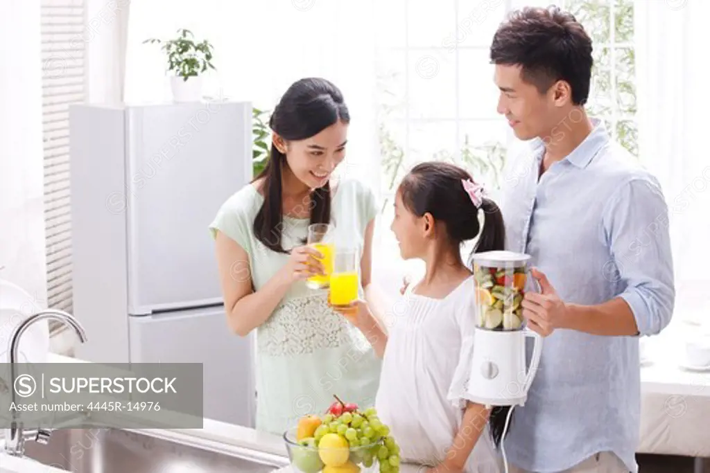 Family drinking juice in kitchen
