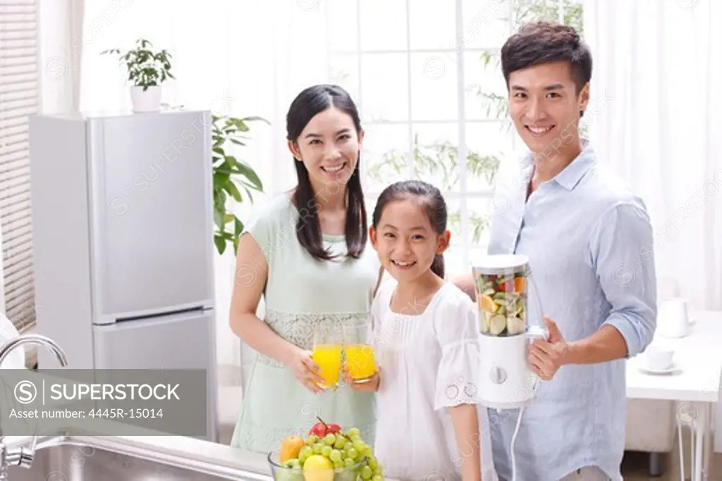 Family holding juice in kitchen