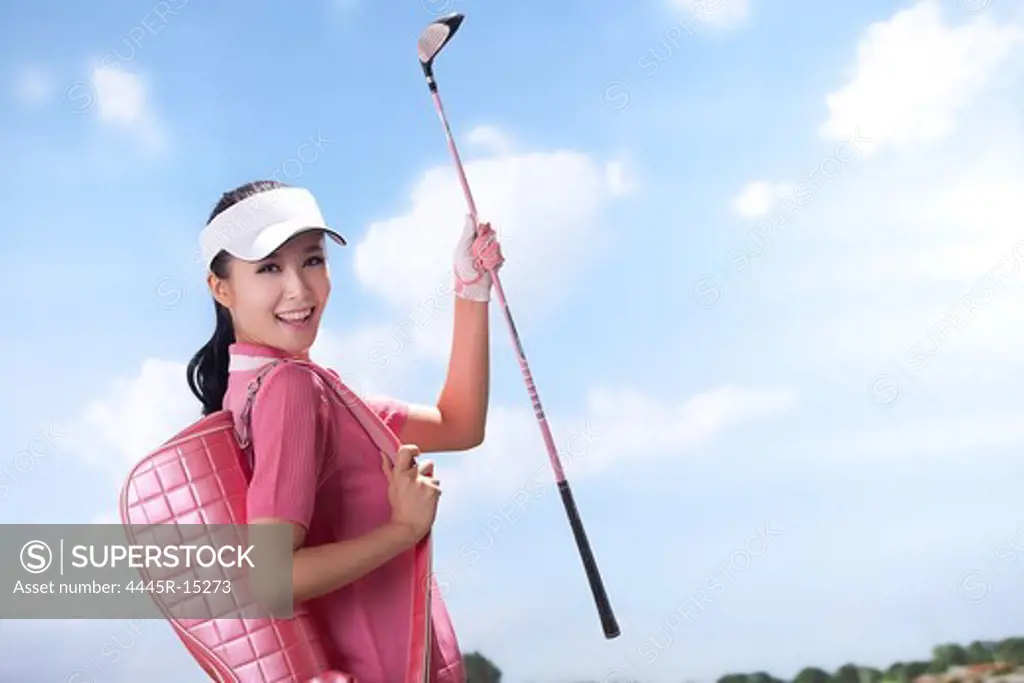Woman carrying golf bag