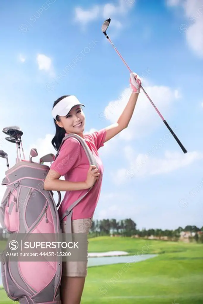 Woman carrying golf bag