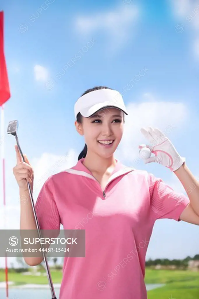 Young woman holding golf ball