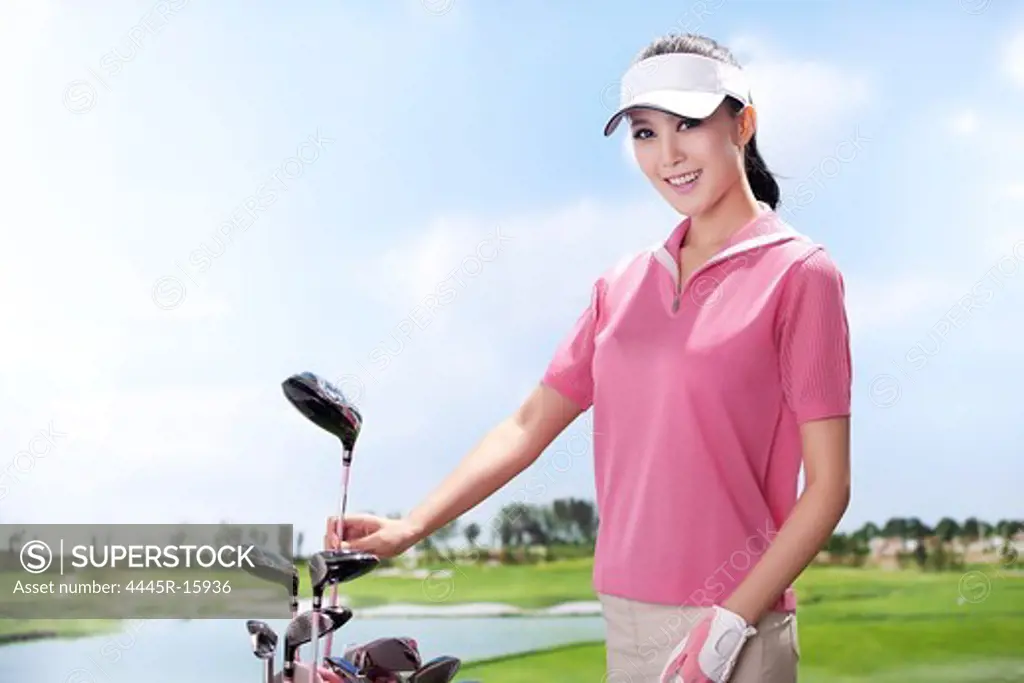 Young woman holding golf clubs