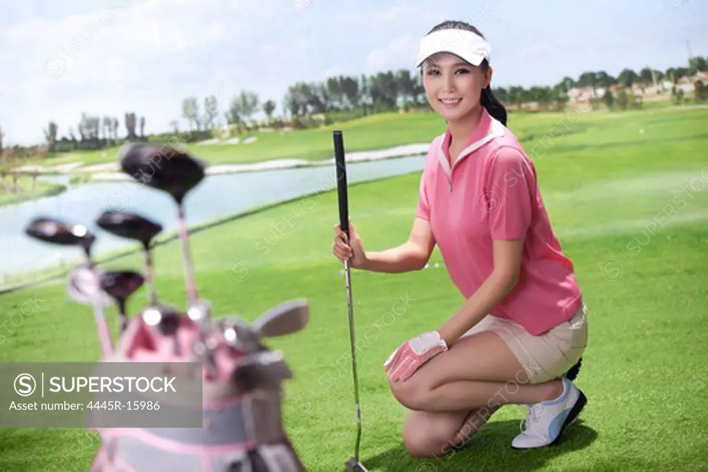 Young woman holding golf clubs