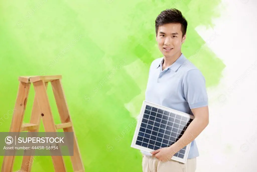 Young man holding a day solar panels