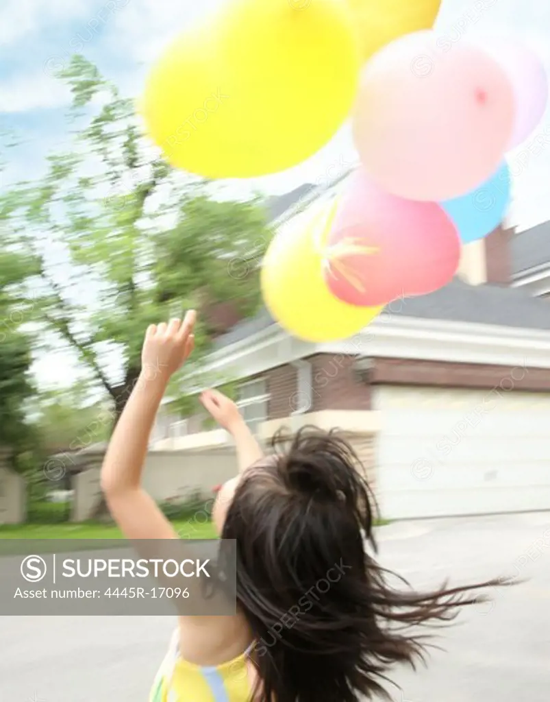 Little girl holding balloons play
