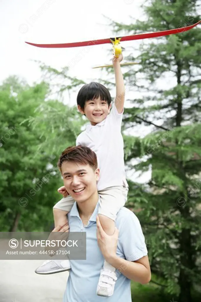 Happy father and son holding a model airplane