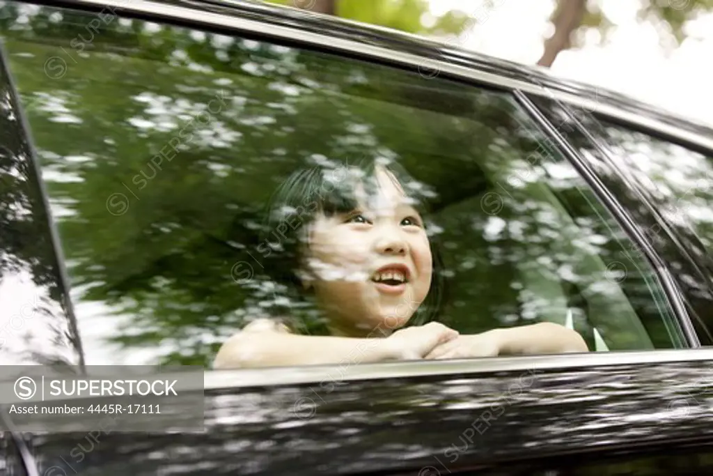 Happy little girl sitting in the car