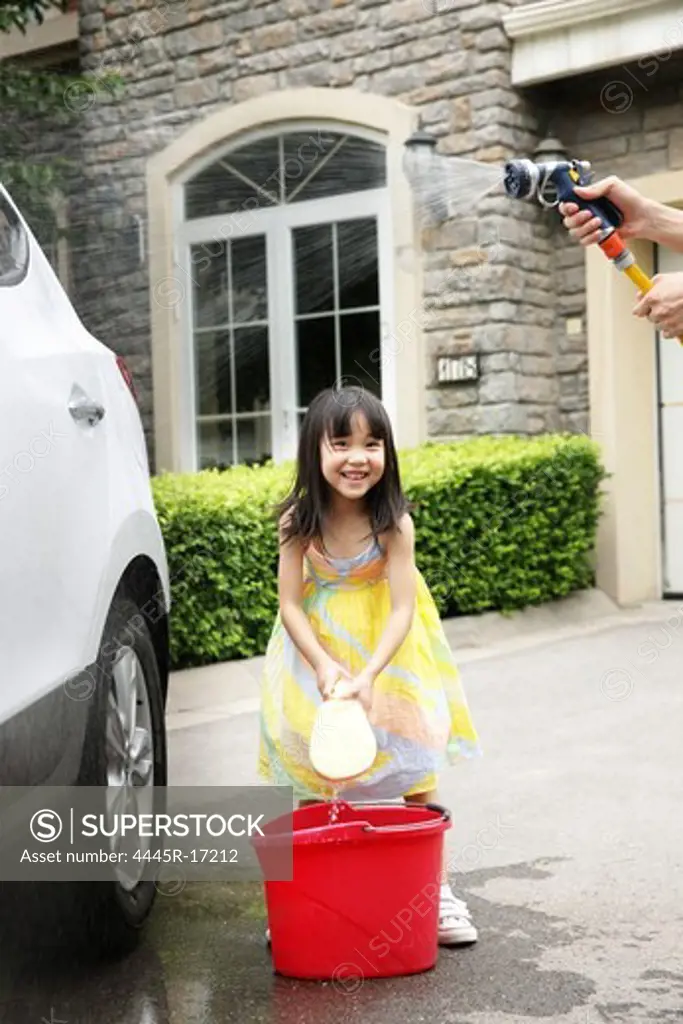 Happy little girl scrubbing cars