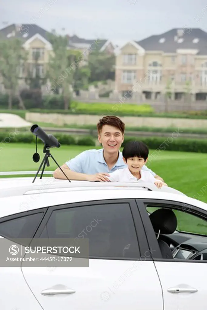 Happy father and son holding binoculars