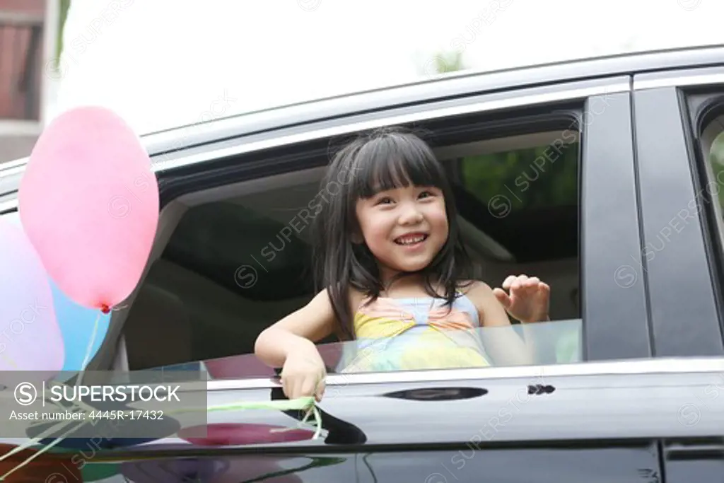 Happy little girl sitting in the car
