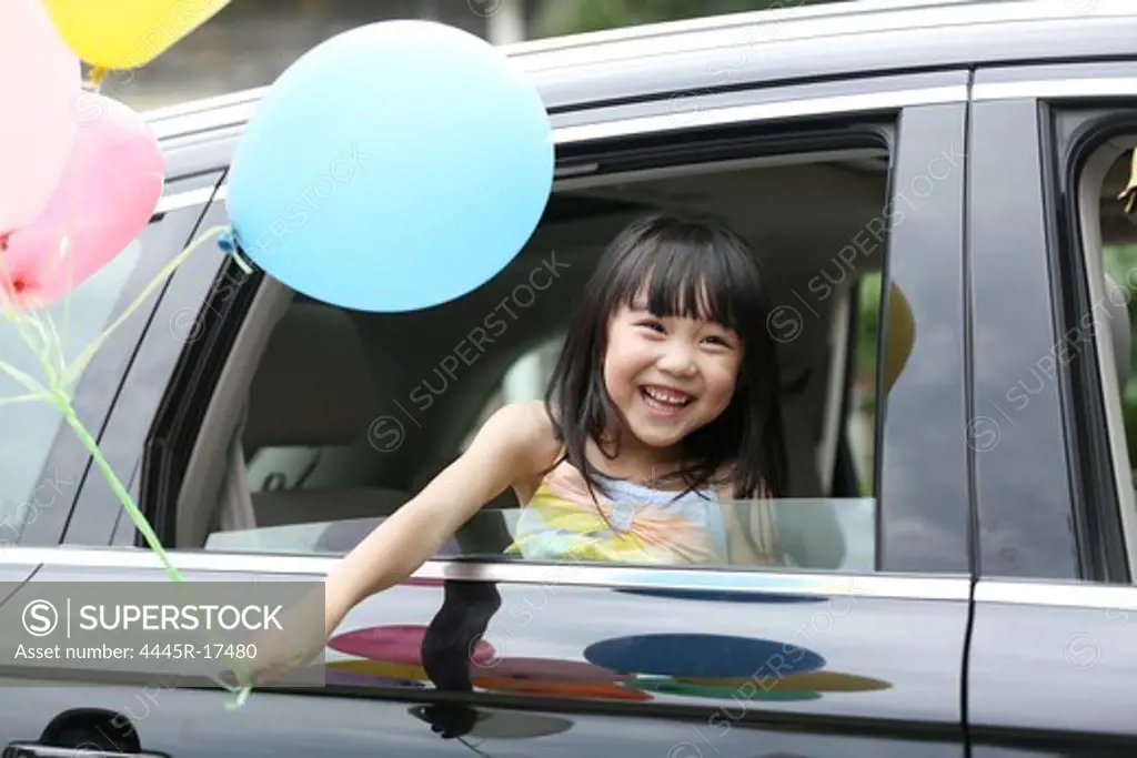 Happy little girl sitting in the car