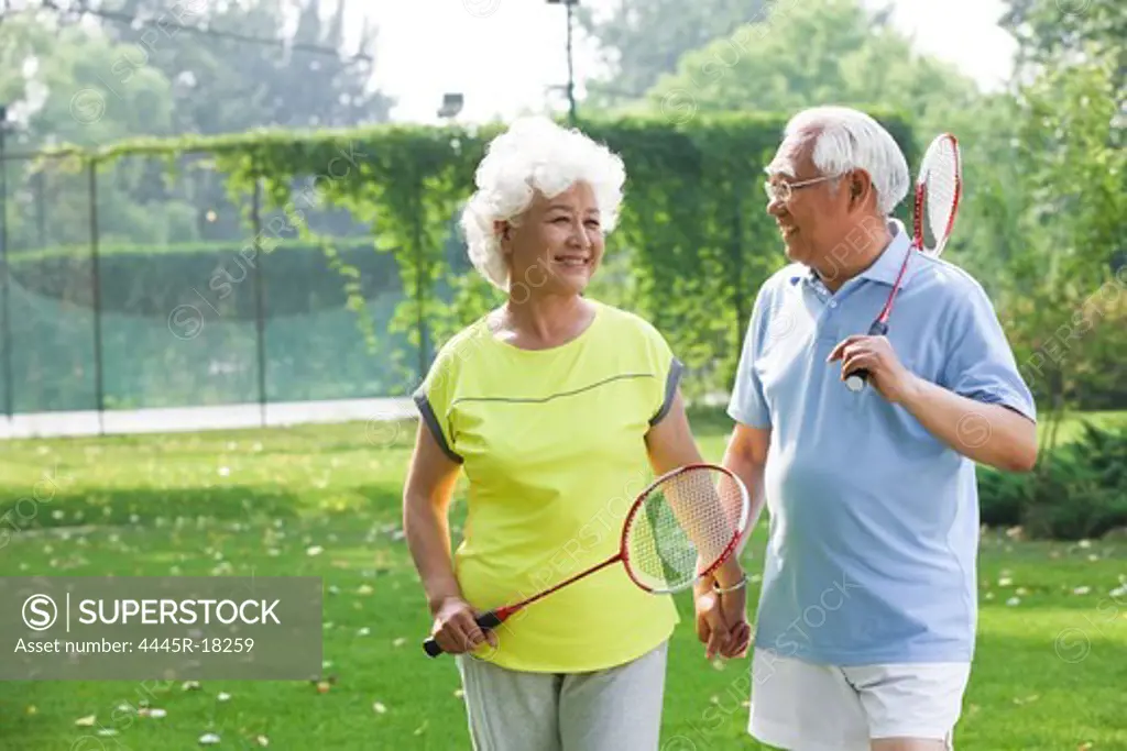 Happy elderly couple playing badminton