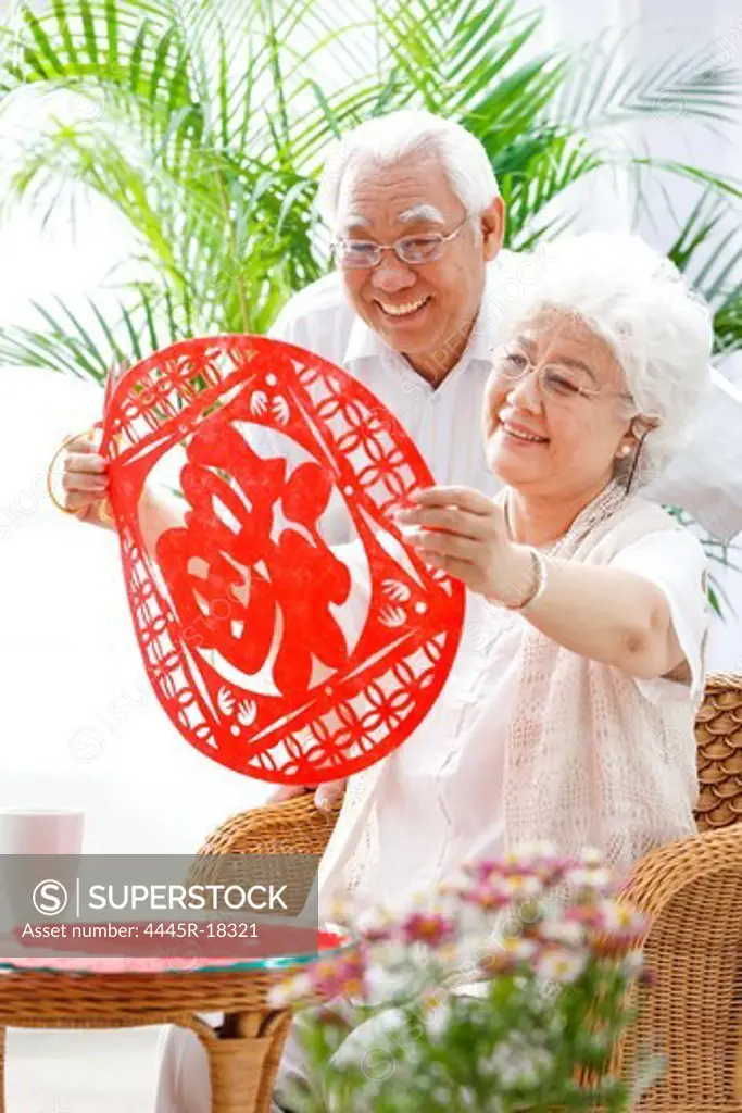 Happy elderly couple holding a good word