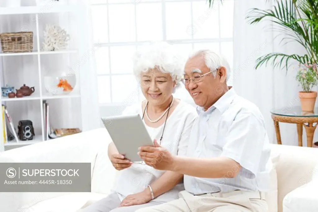Happy elderly couple using a tablet computer