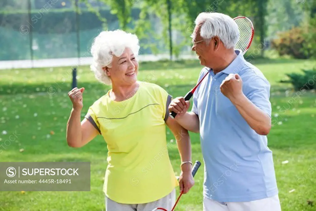 Happy elderly couple playing badminton