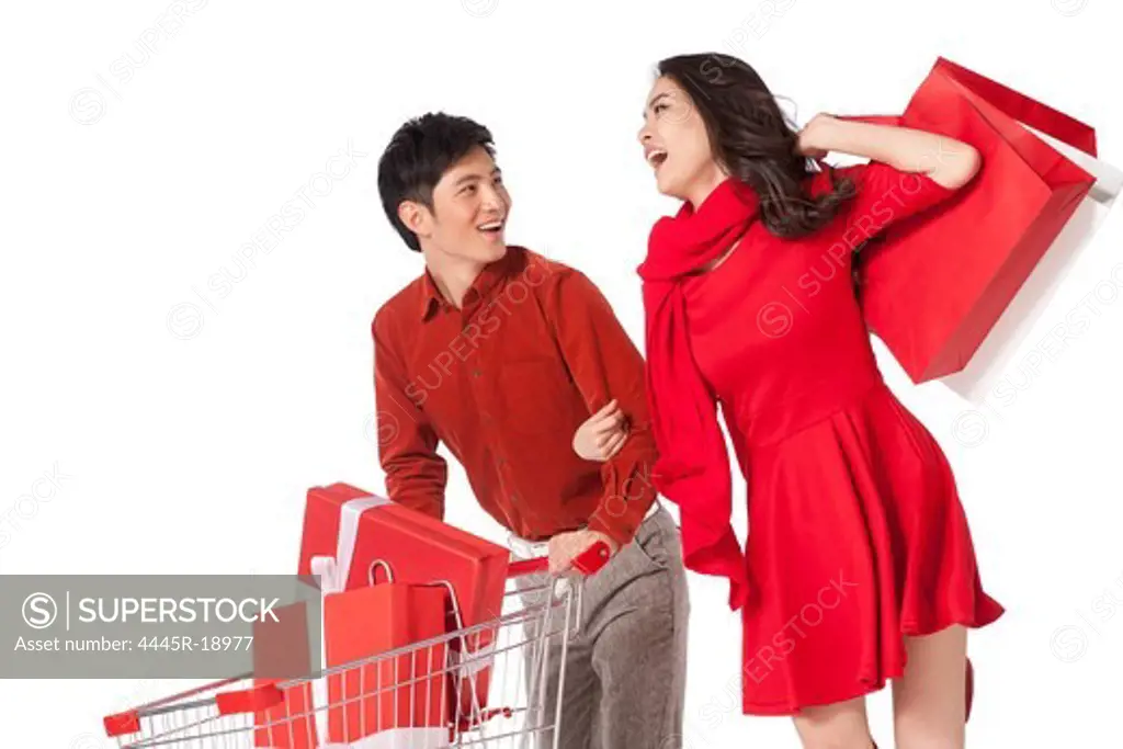 Young couple pushing a shopping cart