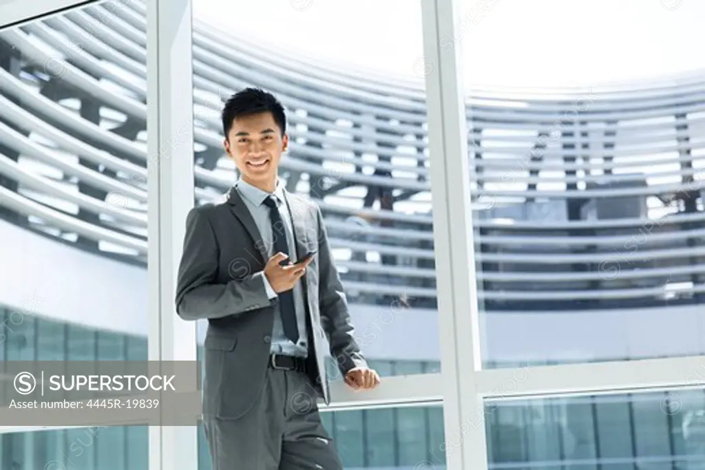 Business man standing in front windows