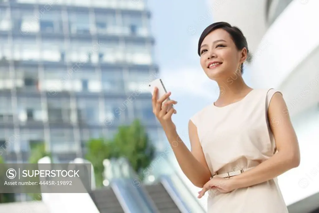 Young business woman looking at cell phone