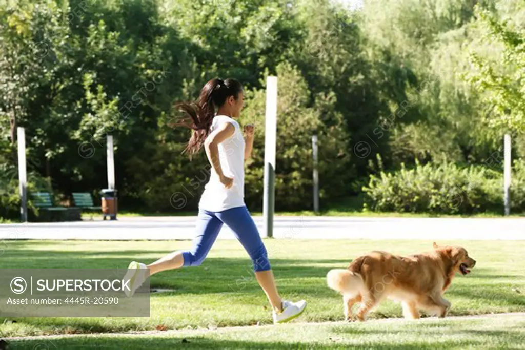 Young woman and dog running together