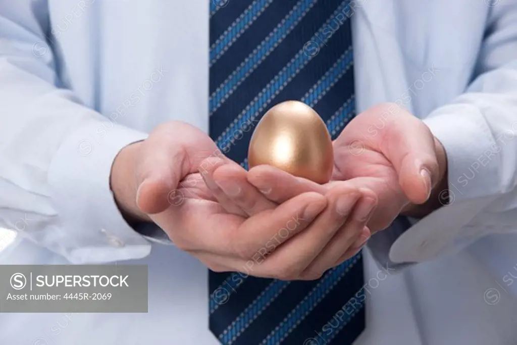 Businessman holding gold egg