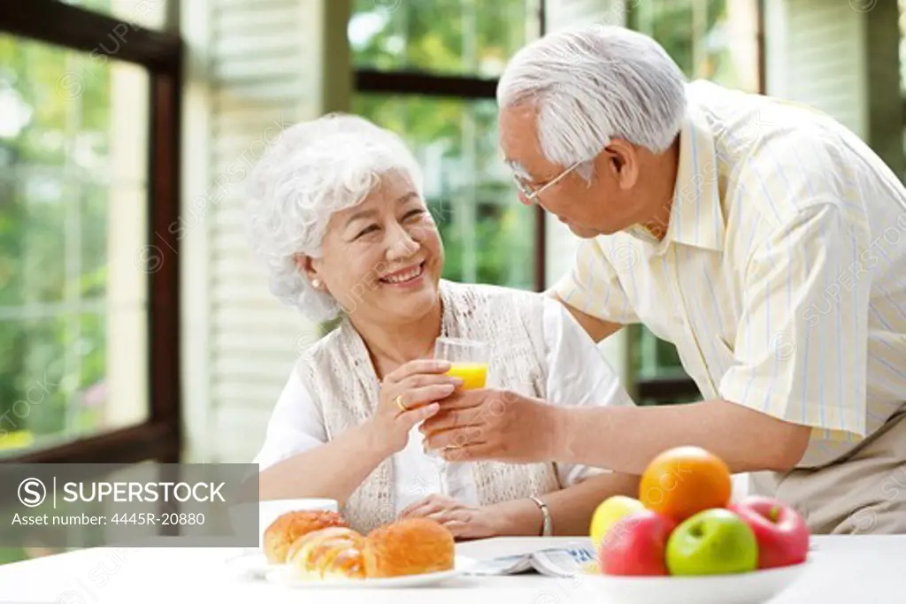 Happy elderly couple drinking juice