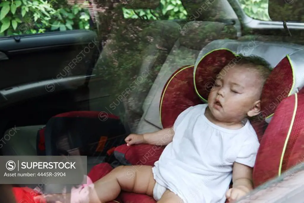 Baby girl asleep in car seat